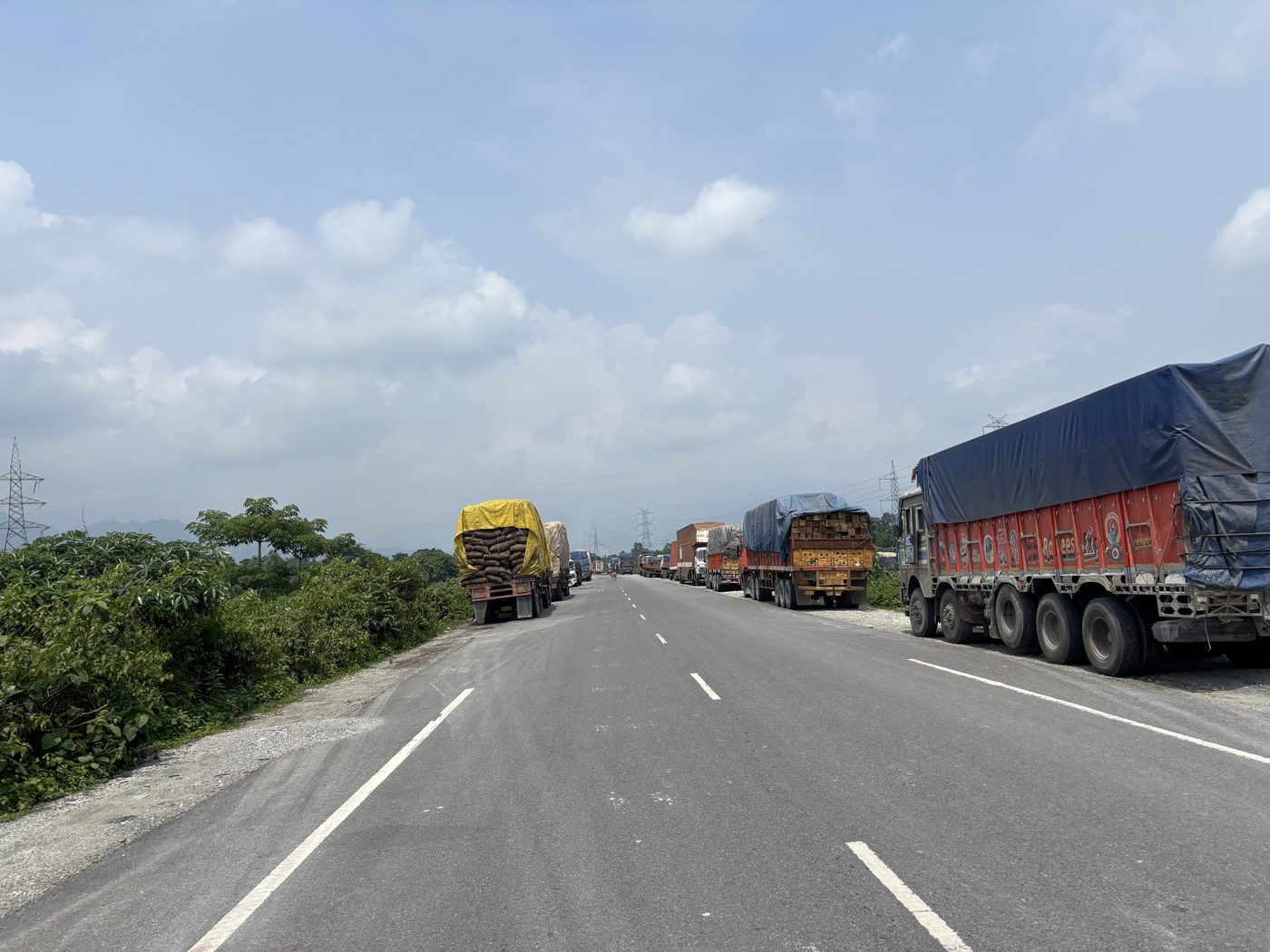 Line of loaded goods trucks on the highway toward the India–Bhutan border at Jaigaon